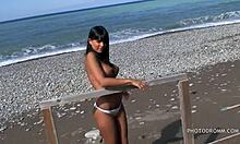 Fjollet teenagebrunette med store falske bryster poserer lige på stranden