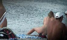 Blondin med en änglalik kropp går runt naken på en strand