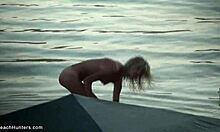 Blond babe viser sin nøgne krop frem, mens hun tager en svømmetur