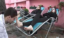 שתי נשים נרגעות בכורסאות ומלקקות את רגליהן