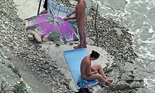 Una amateur de cabello oscuro con gafas está desnuda en la playa. ¡Mira cómo se divierten!