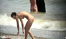 Тъмнокоса гола мацка се разхожда гола на плажа