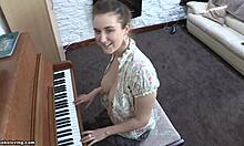 Morena brincalhona com seios empinados tocando piano sem blusa