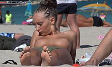 Petite amie amateur bronzée exhibant ses seins sur une plage nudiste en HD