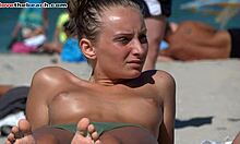 Opalona amatorska dziewczyna prezentuje swoje piersi na plaży nudystów w jakości HD