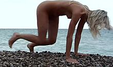 Blondi poseeraa täysin alasti kallioisella rannalla