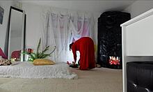 Érzéki, érett Sonias házi videója, amely egy hosszú piros ruhában mutatja be incselkedő pózait, felfedve szőrös szoknyáját, lábát, lábát és csípőjét, természetes mellekkel