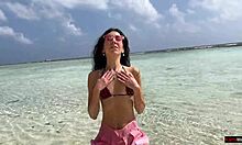 Gyllene dusch på en strand i Maldiverna för en vacker tjej som kissar